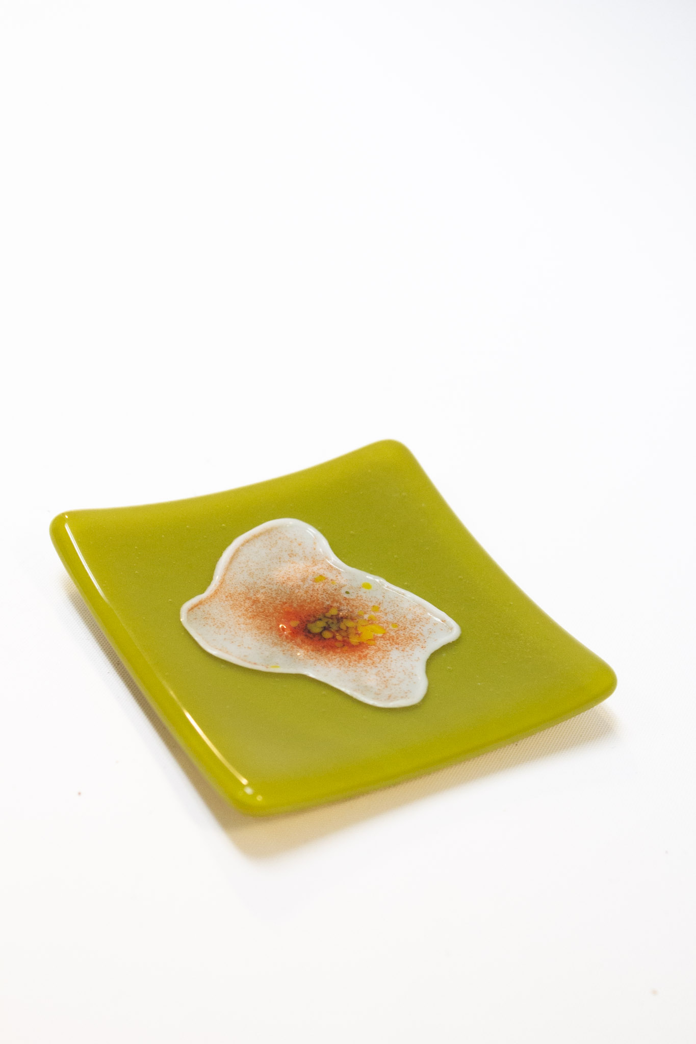 Green square piece of glass with flower painted inside